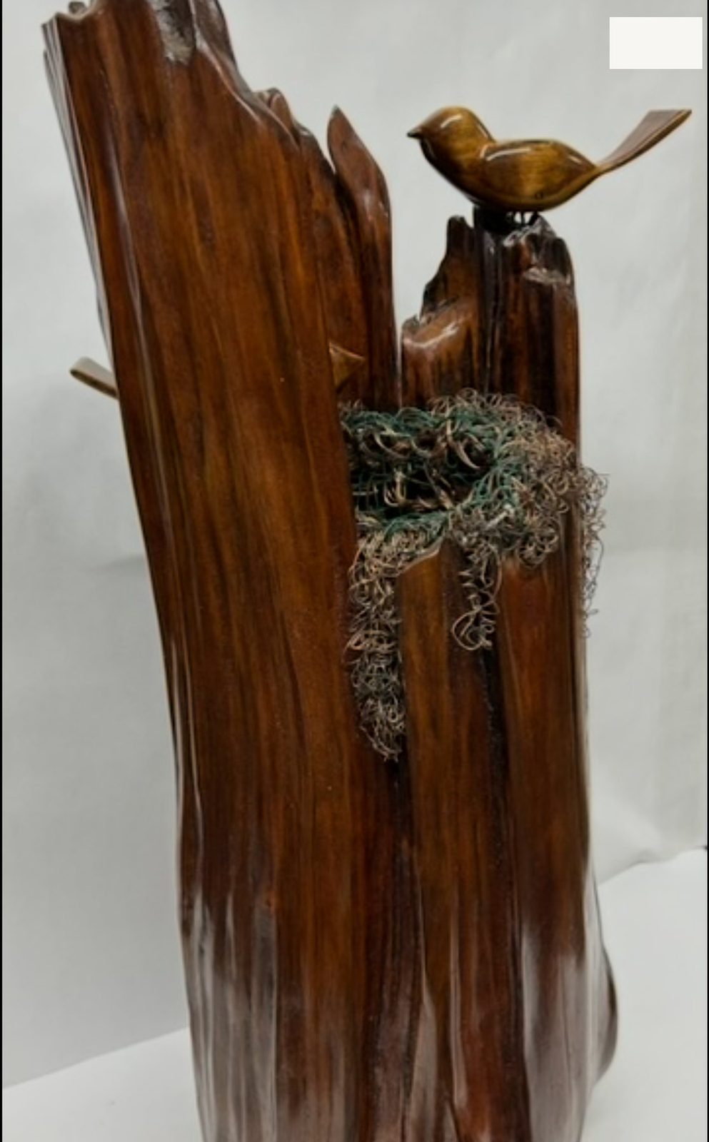 Bird's Nest sculpture, a cherry log with a copper wire nest, carved eggs and sparrows, by Charles Shill