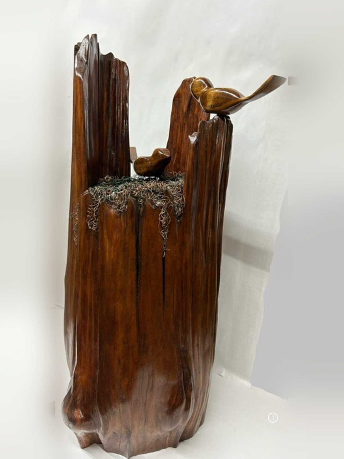 Bird's Nest sculpture standing full height, a cherry log with a copper wire nest and two sugar maple sparrows, by Charles Shill
